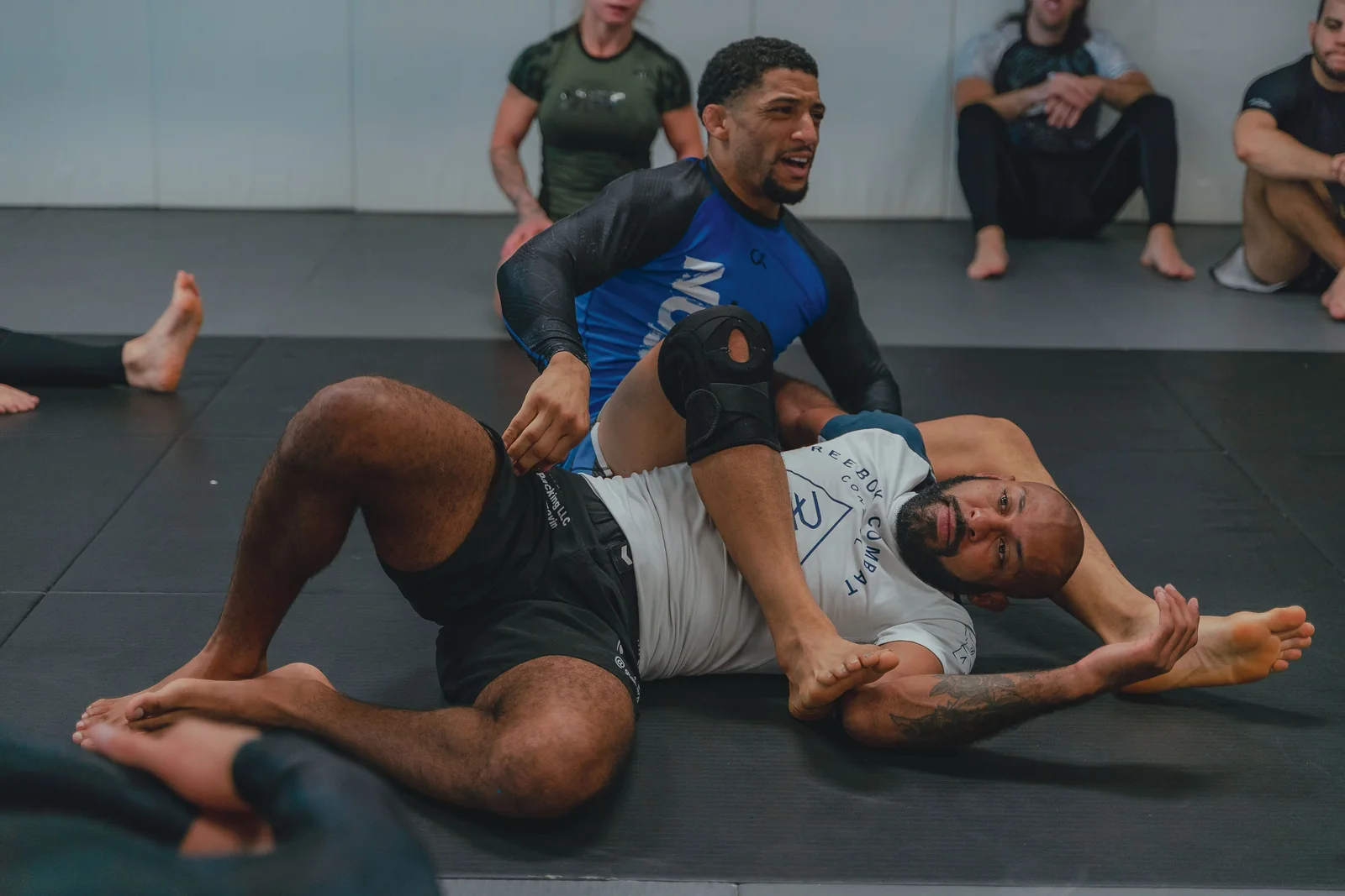 Twee trainingspartners oefenen No-Gi grappling op de mat.