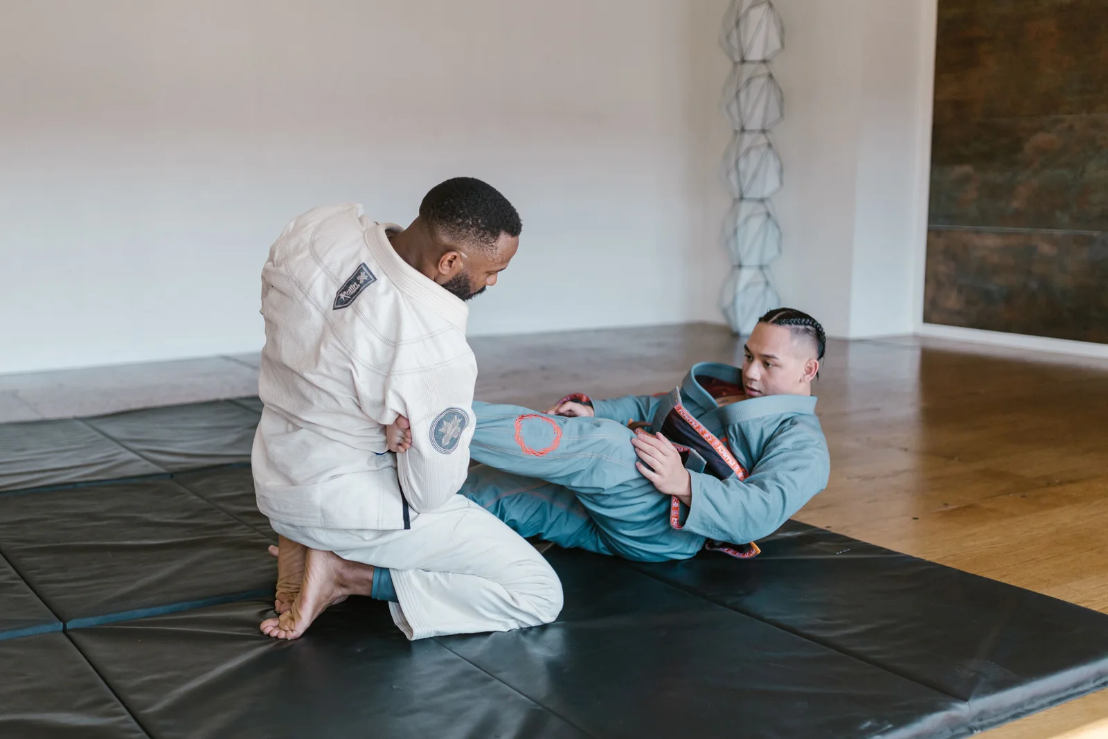 Twee BJJ-beoefenaars oefenen vanuit een guardpositie.