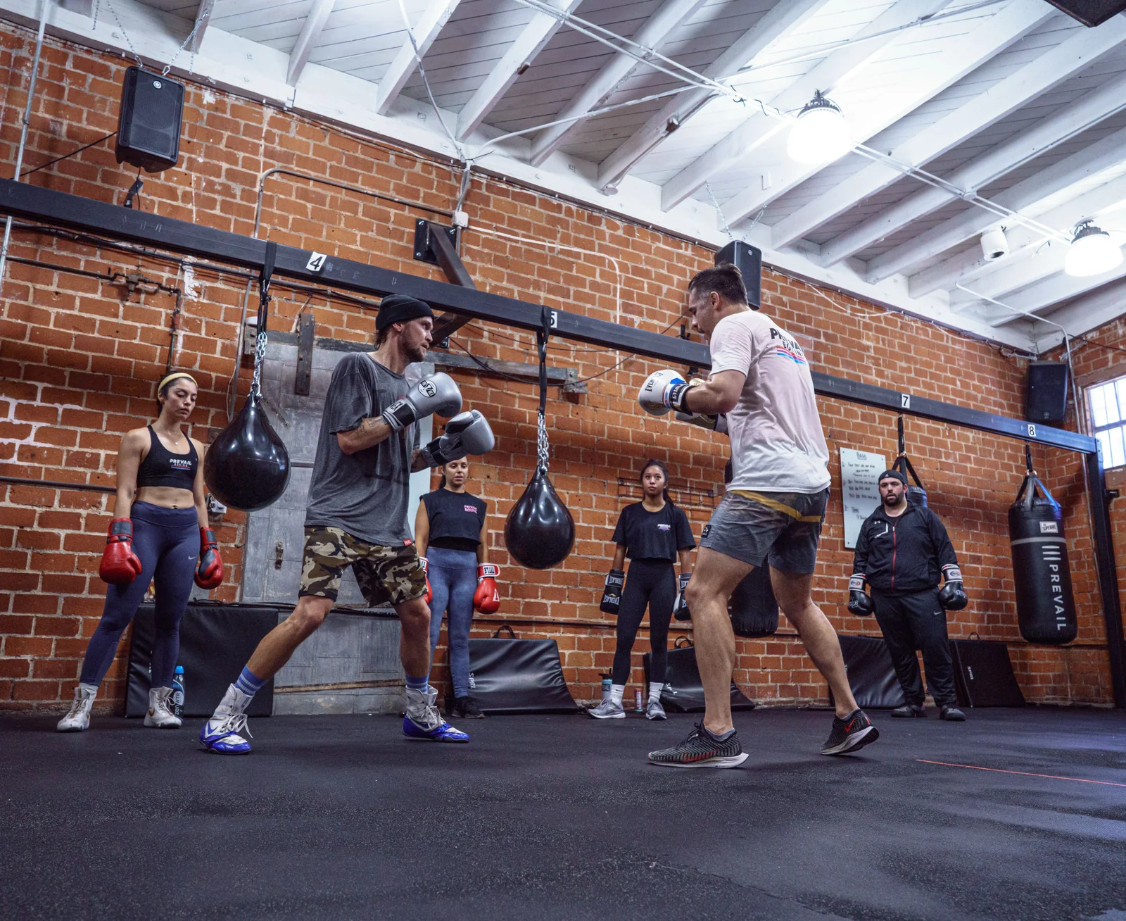 Volwassenen oefenen samen in een boksgym.