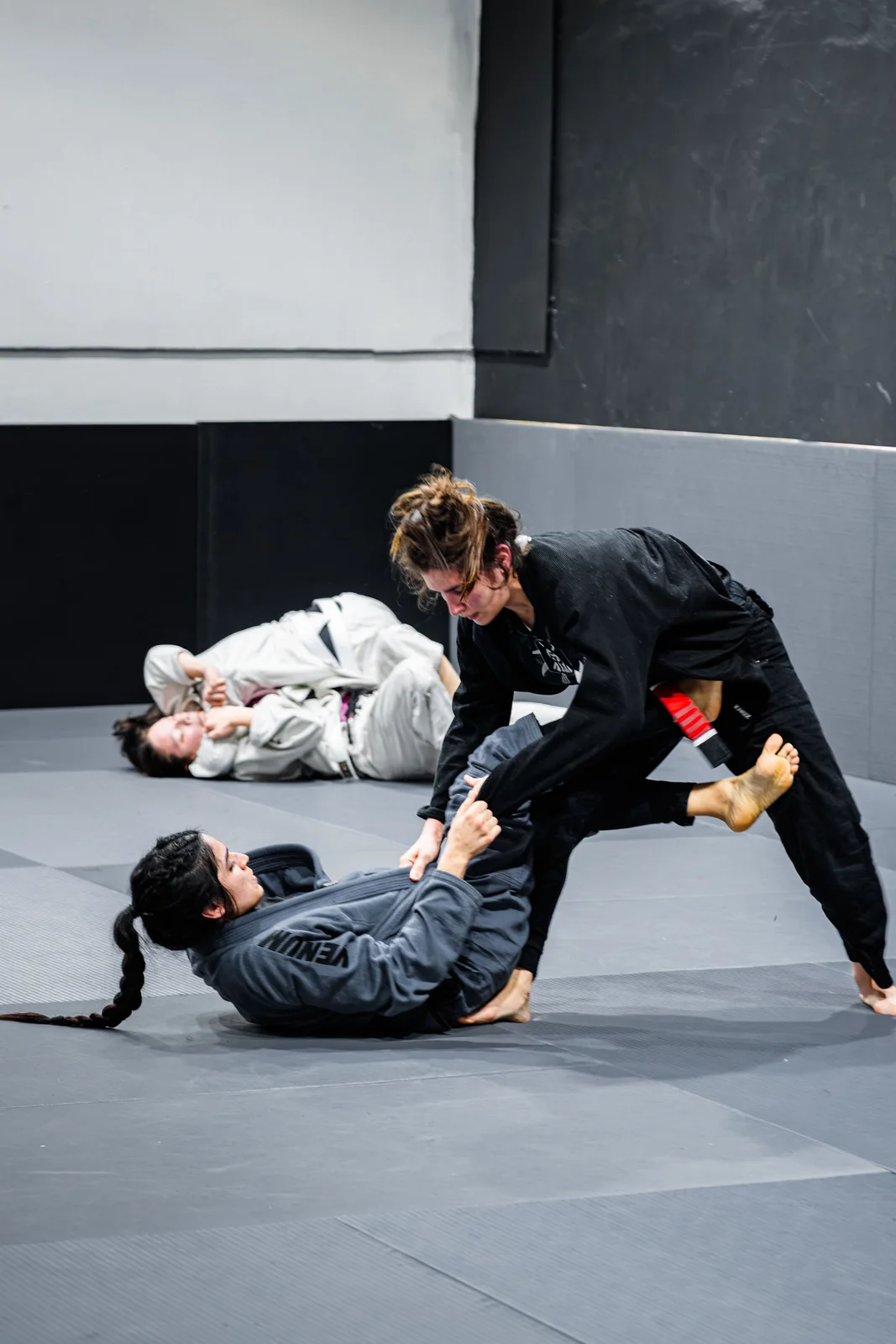 Twee BJJ-beoefenaars oefenen een grondpositie in gi.