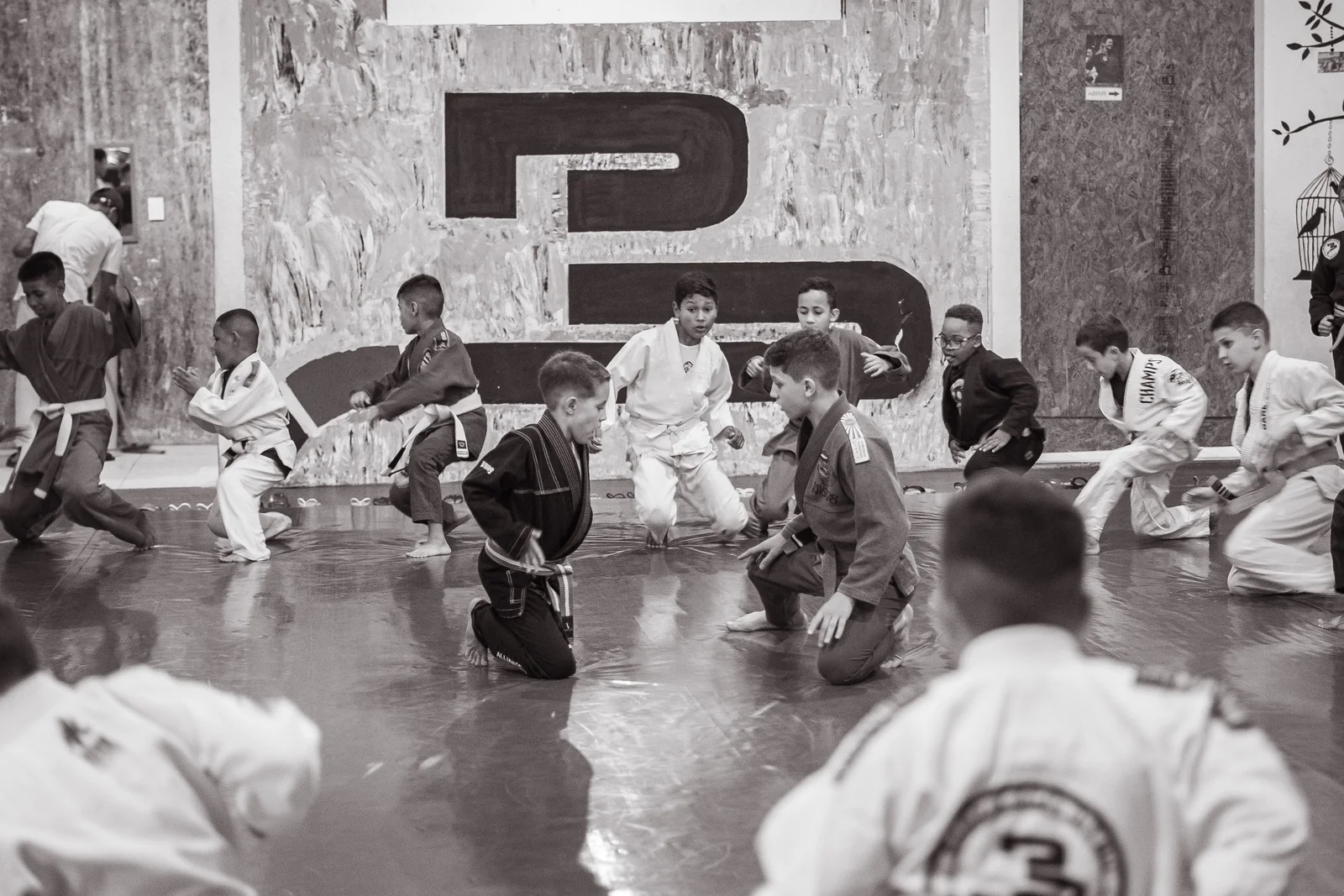 Kinderen volgen samen met hun instructeurs een BJJ-les.